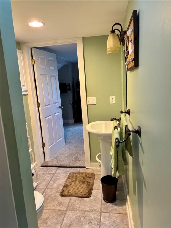 bathroom with tile patterned flooring, toilet, and baseboards