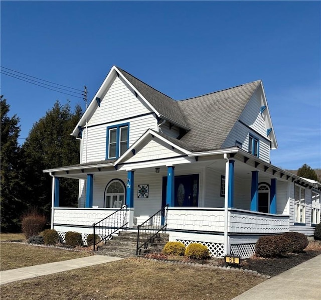 farmhouse-style home with roof with shingles and covered porch