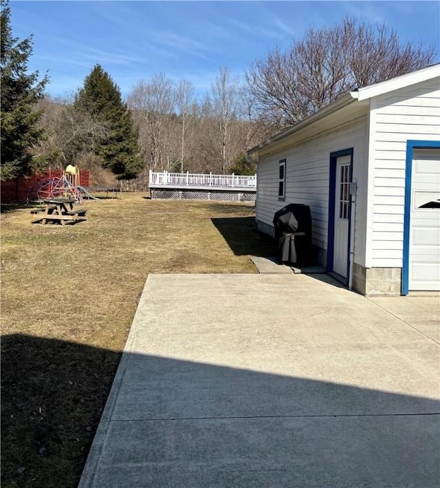 view of yard with a playground, a patio area, and a garage