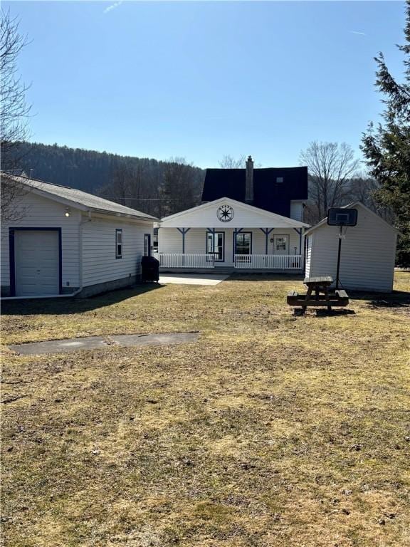 back of house with covered porch and a garage