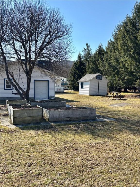 view of yard with an outbuilding, a vegetable garden, and a garage