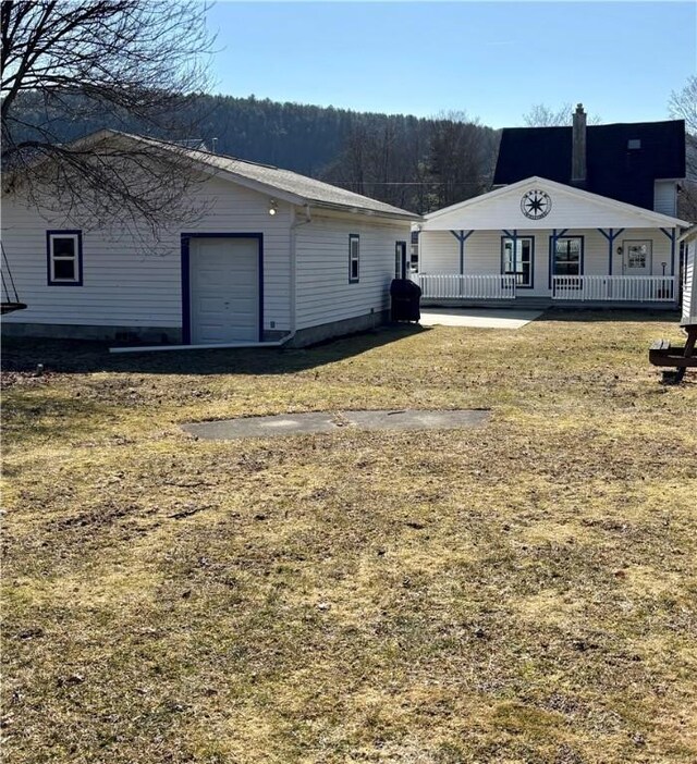 back of property with a garage and covered porch