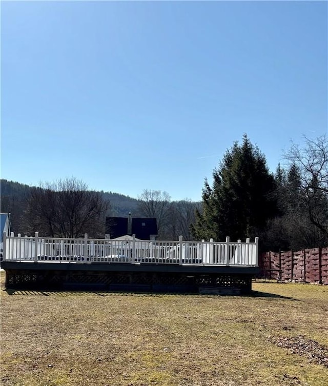 view of yard with a deck and a view of trees