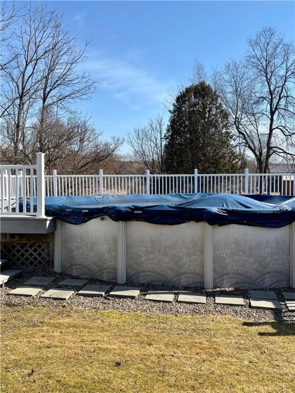 view of pool featuring a covered pool, a yard, and a deck