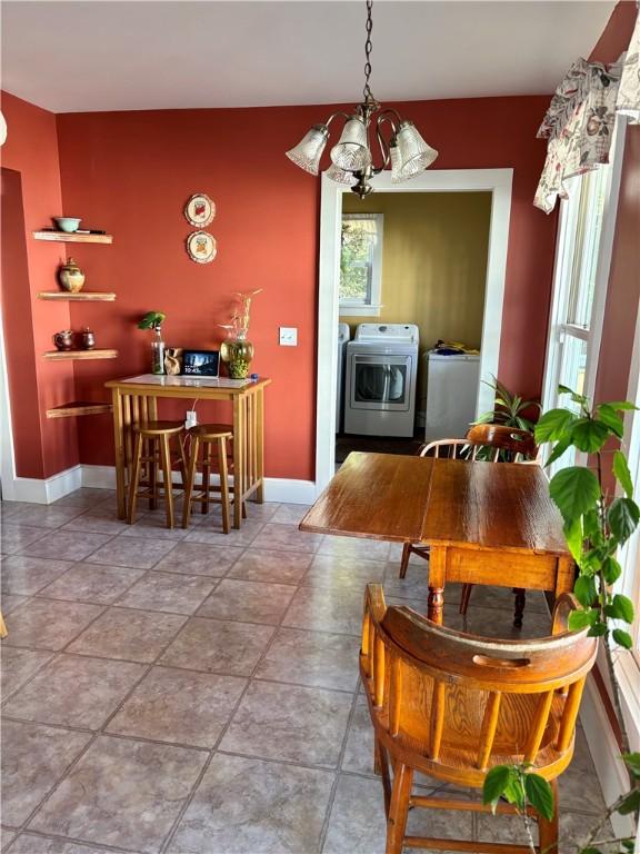 dining area with baseboards, washer / clothes dryer, and a chandelier