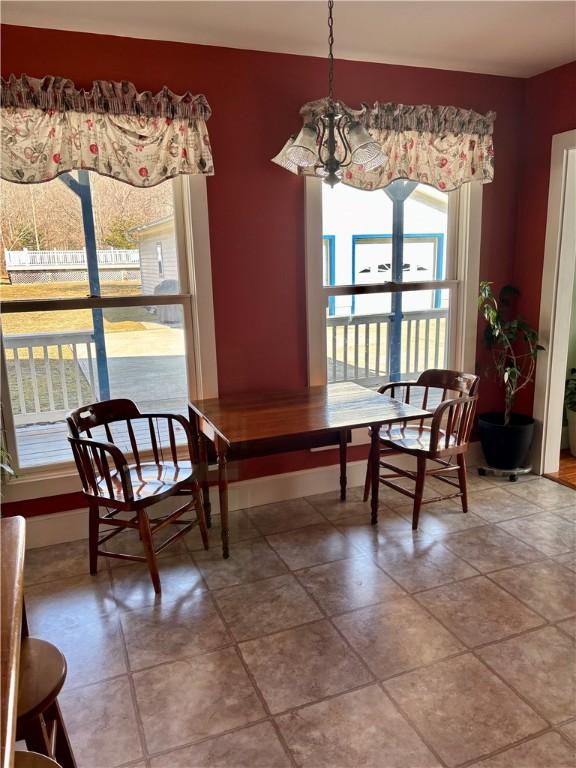 dining area featuring baseboards and a chandelier