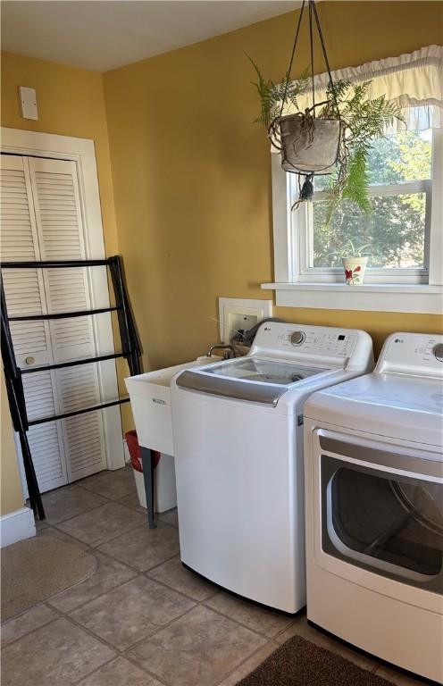 laundry room with washer and dryer, laundry area, and light tile patterned floors