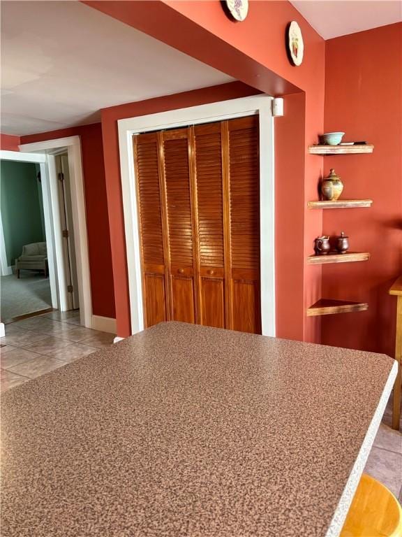 interior space with a closet, baseboards, and tile patterned flooring