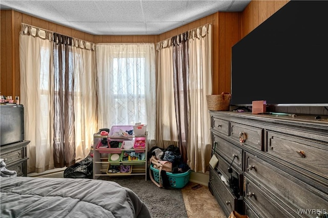 carpeted bedroom featuring wood walls