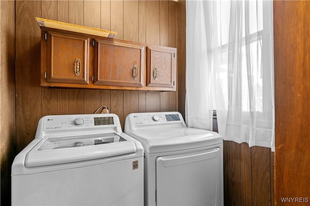 laundry area featuring washing machine and clothes dryer and cabinet space