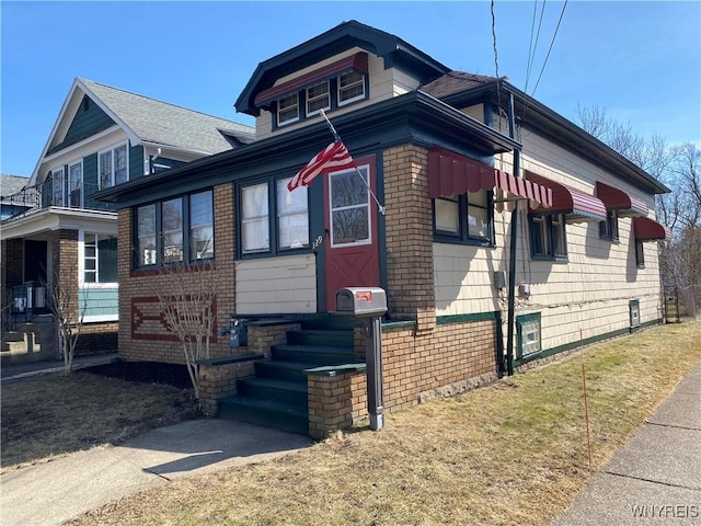 view of front of home with entry steps and brick siding