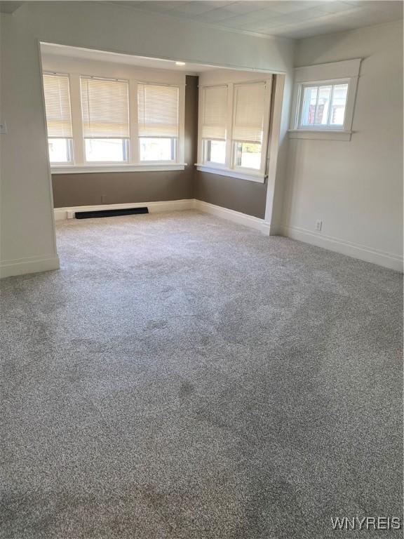 unfurnished room with baseboards and carpet