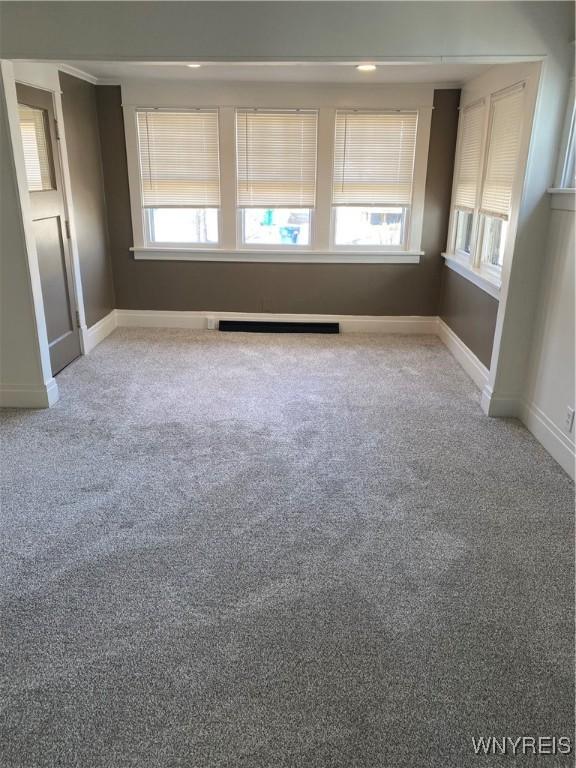 spare room with visible vents, carpet, and baseboards