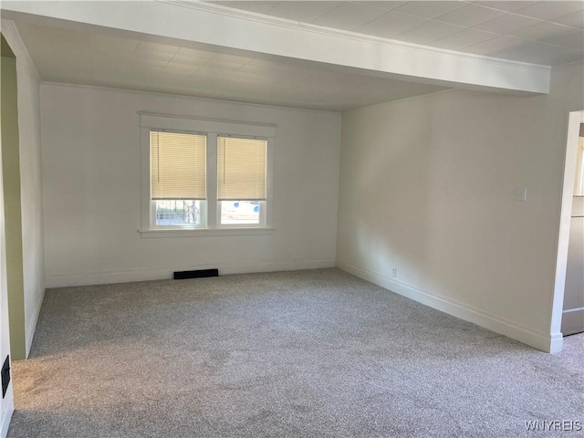 unfurnished room featuring carpet flooring, baseboards, visible vents, and ornamental molding