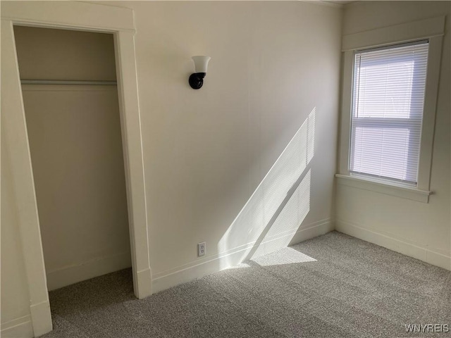 unfurnished bedroom with a closet, baseboards, and carpet