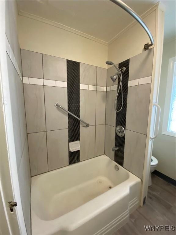 full bath with shower / bath combination, toilet, wood finished floors, and ornamental molding