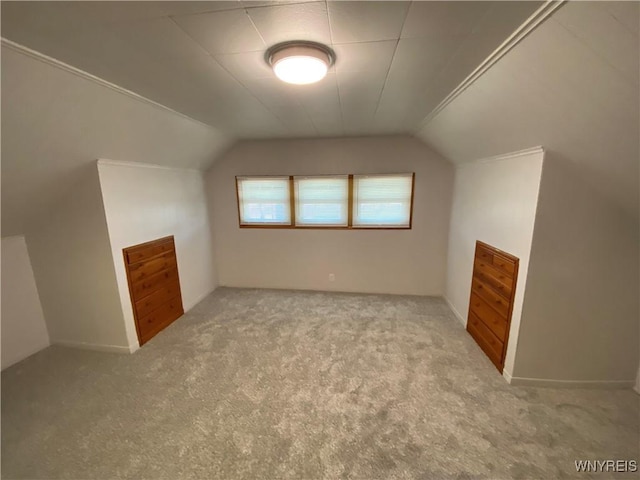 bonus room with vaulted ceiling and carpet flooring