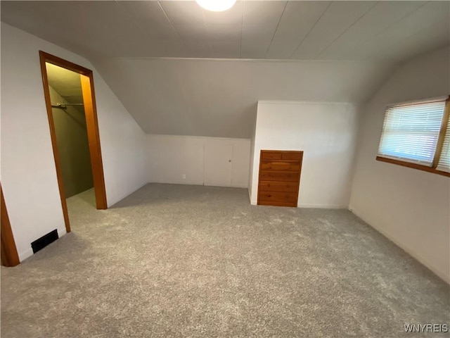 bonus room with lofted ceiling and carpet floors