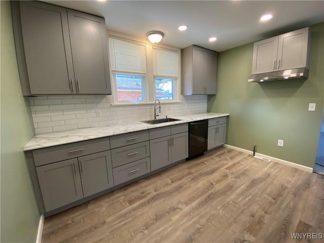 kitchen with a sink, dishwasher, gray cabinetry, and light wood finished floors