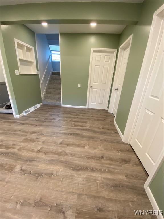 interior space with visible vents, stairs, baseboards, and wood finished floors