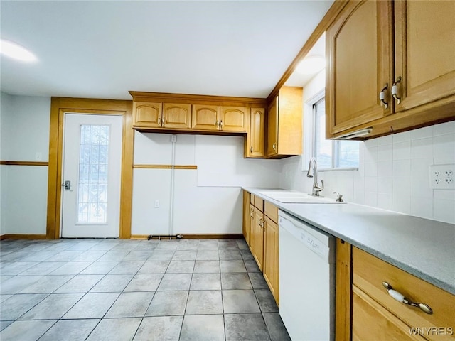 kitchen with a sink, backsplash, light countertops, light tile patterned floors, and dishwasher