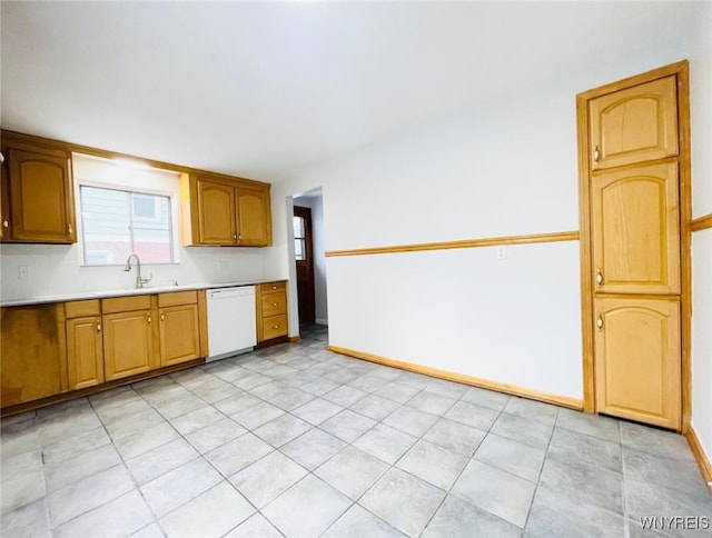 kitchen featuring a sink, baseboards, dishwasher, and light countertops