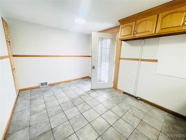 interior space with light tile patterned floors, baseboards, and visible vents