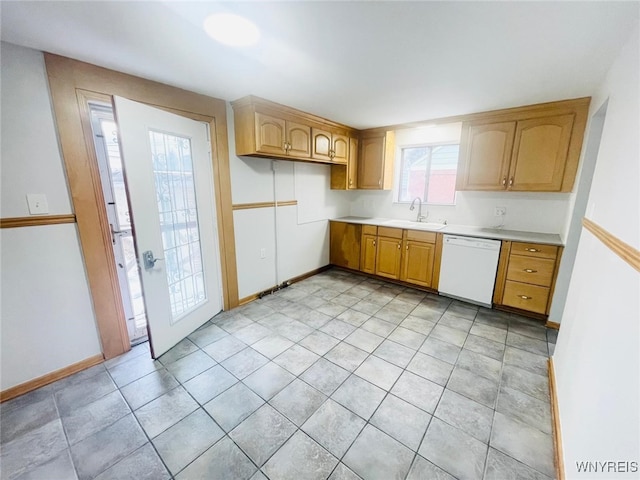 kitchen with a sink, light countertops, baseboards, and white dishwasher