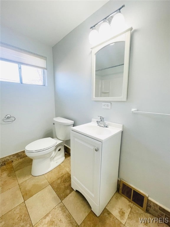 bathroom featuring visible vents, toilet, vanity, and baseboards