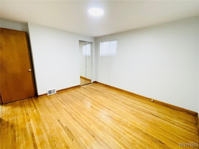 unfurnished bedroom with visible vents, baseboards, a closet, and light wood finished floors