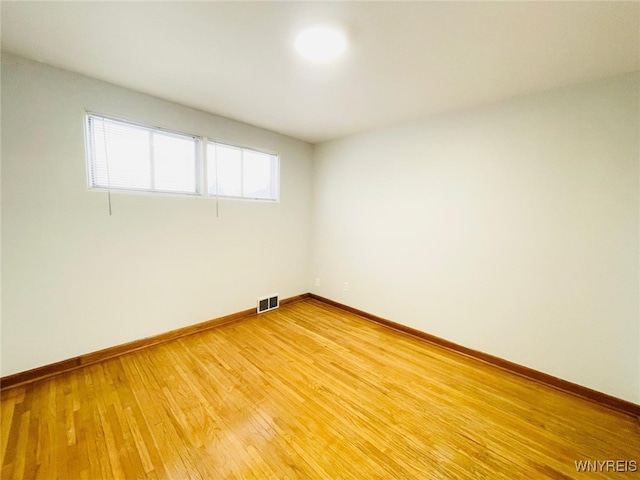 unfurnished room featuring visible vents, light wood-type flooring, and baseboards