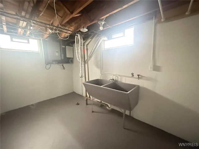 basement with electric panel and a sink