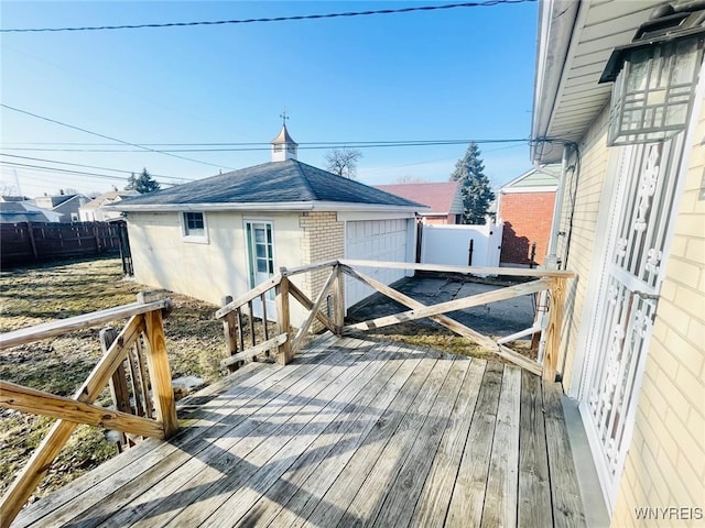 wooden deck with a garage, an outdoor structure, and fence