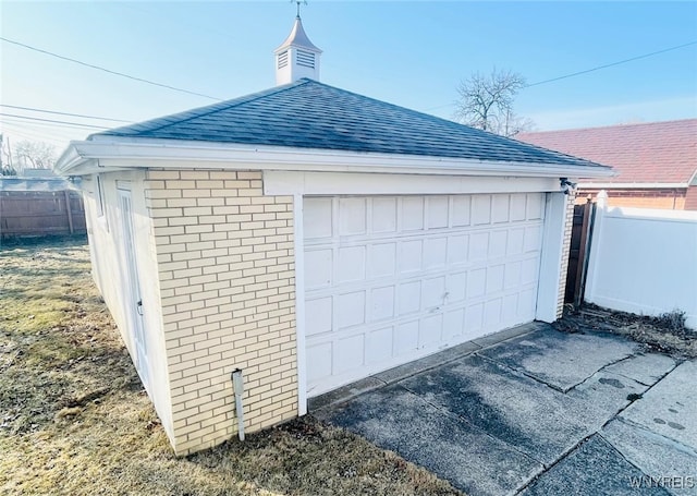 detached garage featuring fence