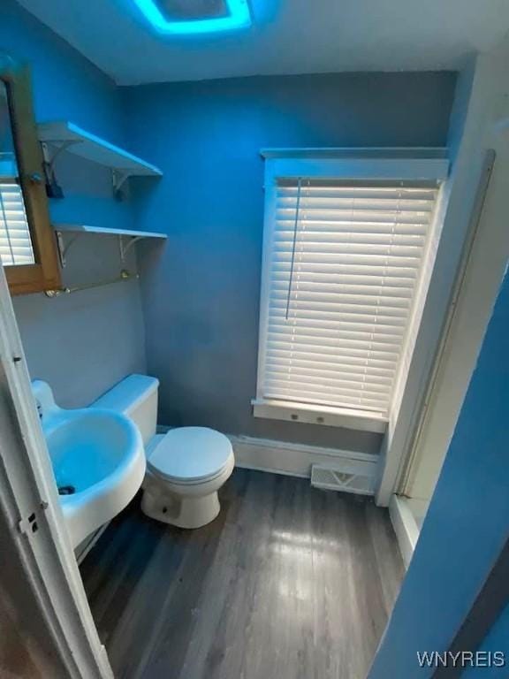 bathroom featuring a sink, baseboards, toilet, and wood finished floors