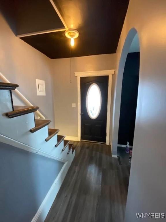 foyer entrance with stairway, wood finished floors, baseboards, and arched walkways