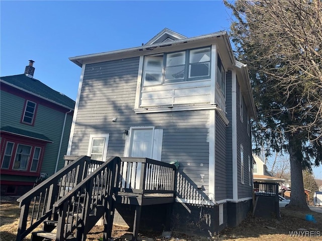 rear view of house with a wooden deck and stairs