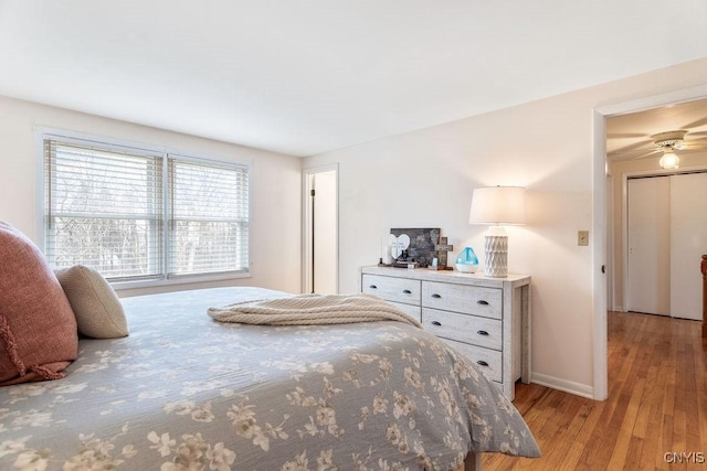 bedroom featuring light wood finished floors and baseboards