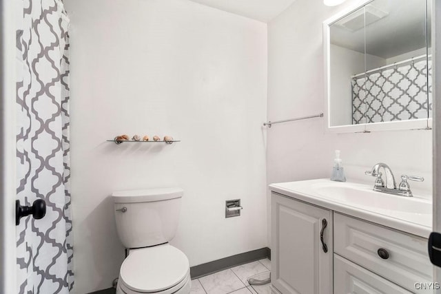 bathroom featuring vanity, baseboards, visible vents, tile patterned floors, and toilet