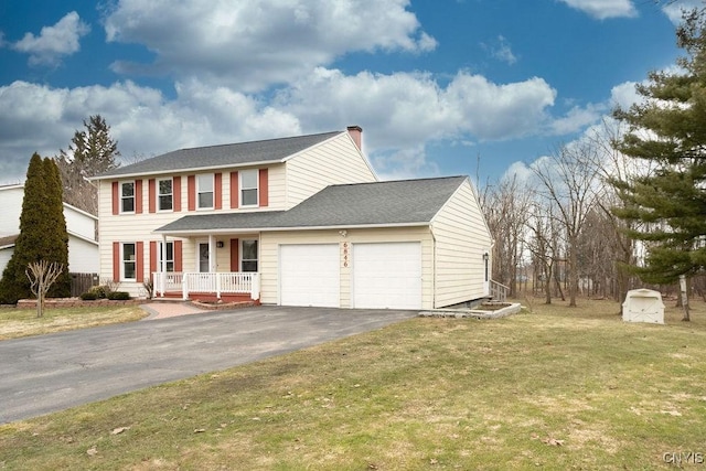 colonial inspired home with an attached garage, a porch, a front yard, a chimney, and driveway