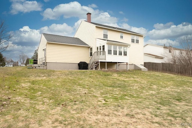 back of house featuring a sunroom, a lawn, a chimney, and fence