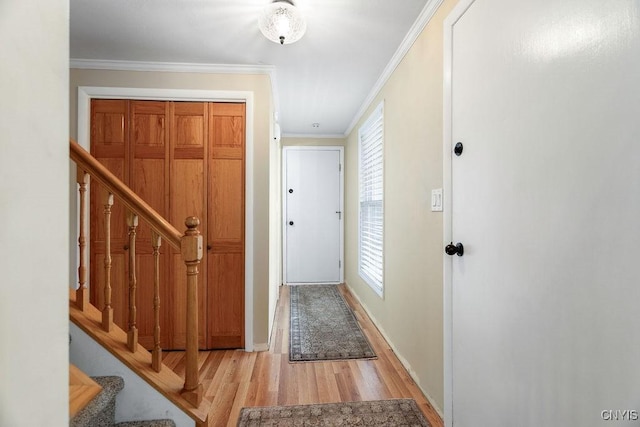 entryway with stairway, light wood-style flooring, and ornamental molding