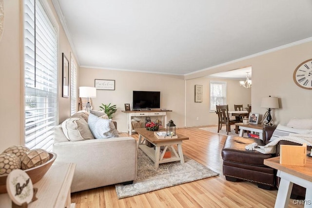 living area featuring crown molding, an inviting chandelier, and wood finished floors