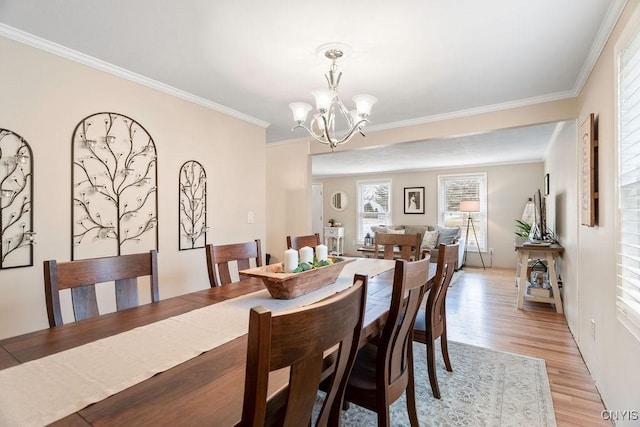 dining area featuring a chandelier, light wood-type flooring, and ornamental molding