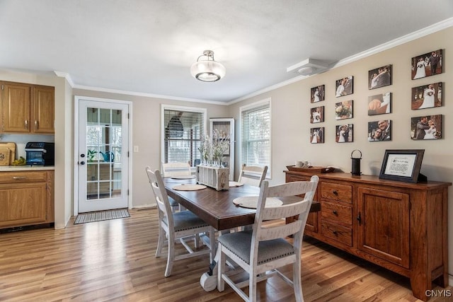 dining room featuring light wood-type flooring and ornamental molding