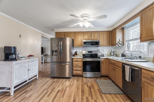 kitchen with a sink, stainless steel appliances, brown cabinets, and light countertops