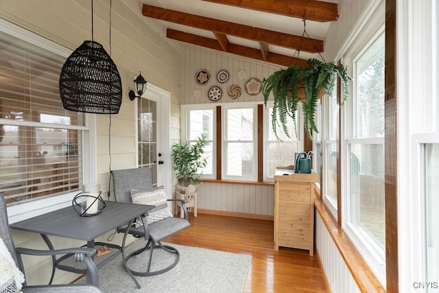 sunroom featuring plenty of natural light and lofted ceiling with beams