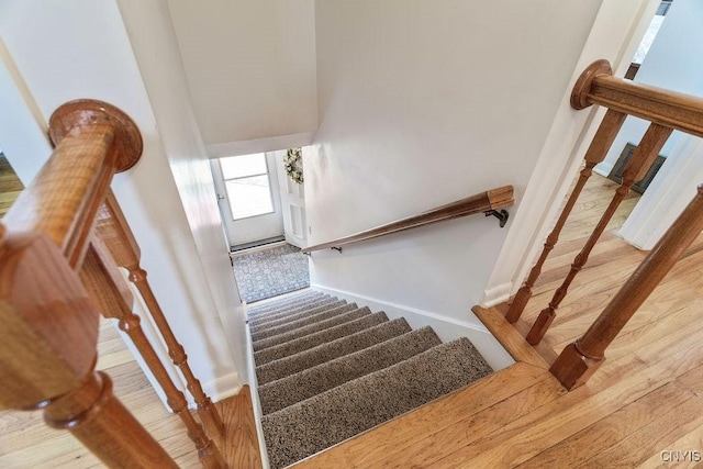 staircase featuring baseboards and wood finished floors