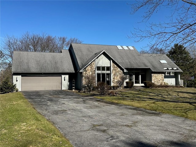 view of front of property featuring a front yard, an attached garage, and driveway