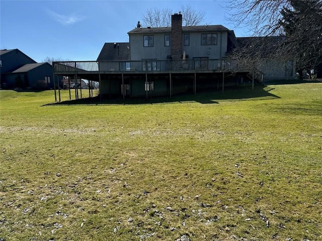 rear view of house with a yard and a deck